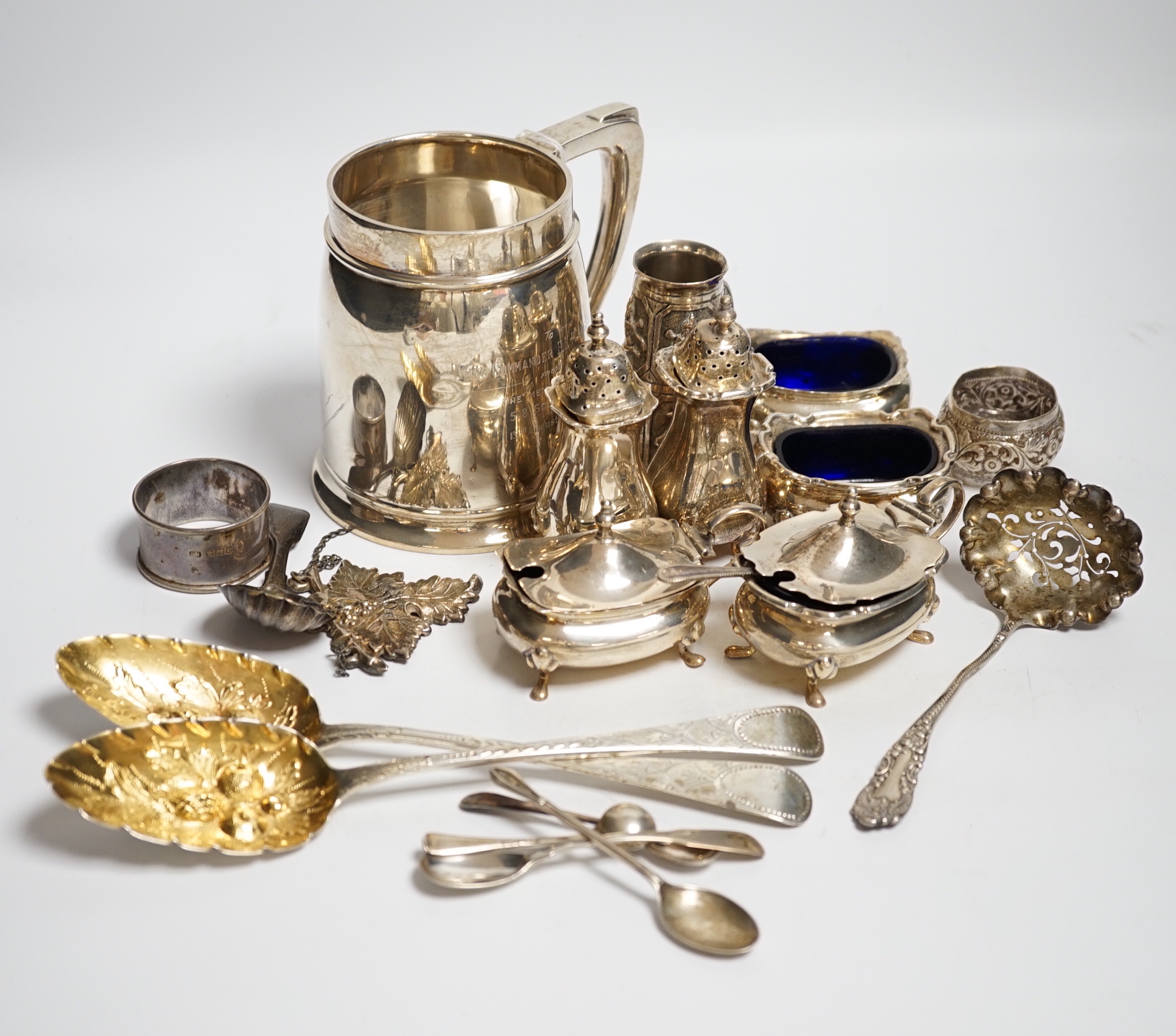 A George VI silver mug, Birmingham, 1937, 11.5cm with engraved inscription to Wing Commander E.E.M Angell, a pair of George III Old English pattern berry spoons, a George IV silver caddy spoons and other items including
